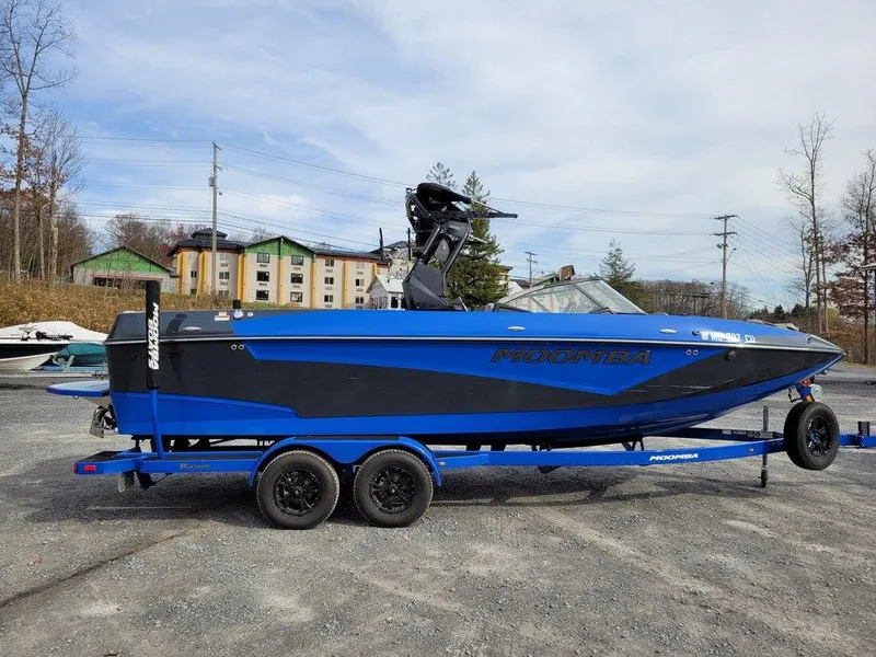 Slide: The Image of 2022 Moomba Makai boat on trailer, blue and black design, parked outdoors. - 6