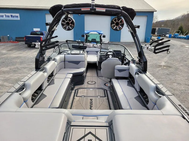 Slide: The Image of 2022 Moomba Makai boat interior with spacious seating and modern design at a marina. - 8