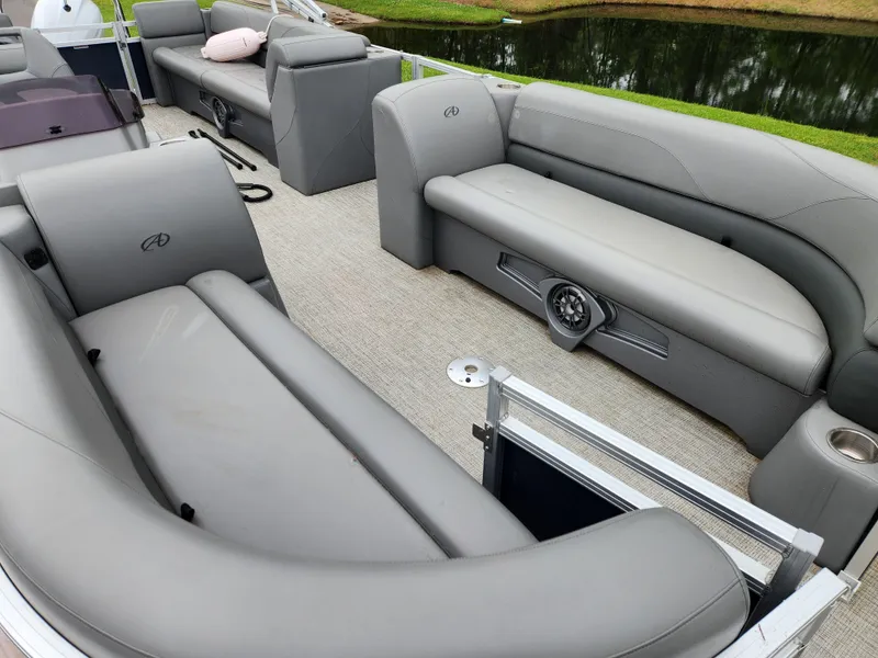 Slide: The Image of 2022 Avalon VLS 2280 QL pontoon boat with gray seating, near a serene lake. - 11