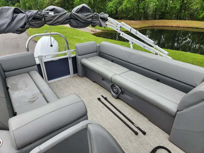 Slide: The Image of 2022 Avalon VLS 2280 QL pontoon boat with gray seating, near a pond. - 12