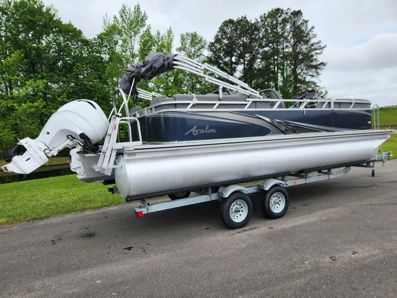 Slide: The Image of 2022 Avalon VLS 2280 QL pontoon boat on trailer, parked outdoors. - 2