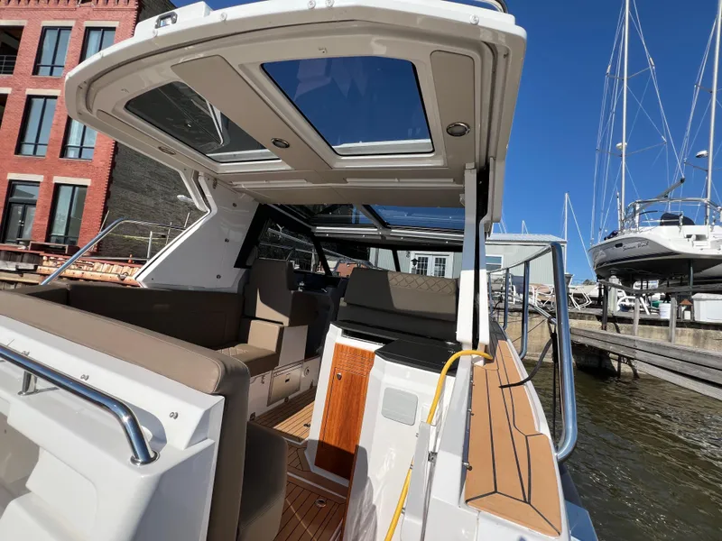 Slide: The Image of 2024 Aquador 250 HT boat interior with open sunroof, docked at marina. - 10