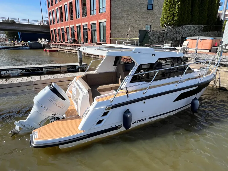 Slide: The Image of 2024 Aquador 250 HT boat docked at a marina, featuring sleek design and modern amenities. - 2