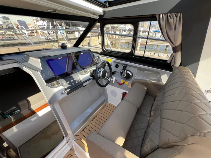 Slide: The Image of 2024 Aquador 250 HT boat interior with modern helm and seating. - 20