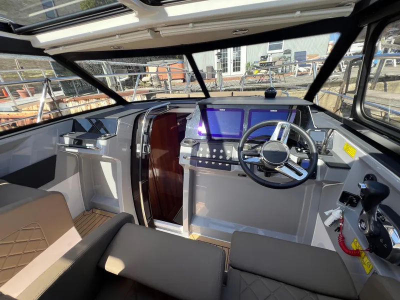 Slide: The Image of 2024 Aquador 250 HT boat interior with modern dashboard and steering wheel. - 21