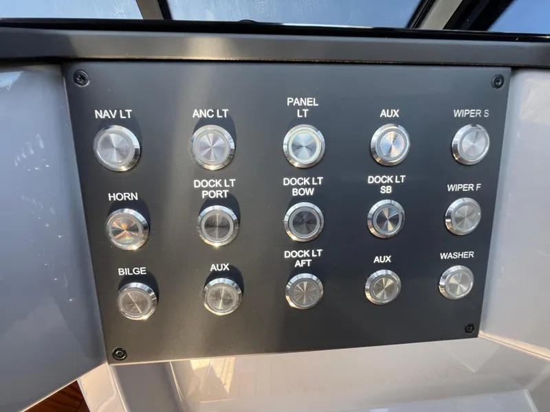 Slide: The Image of Control panel of 2024 Aquador 250 HT boat with labeled buttons for various functions. - 23