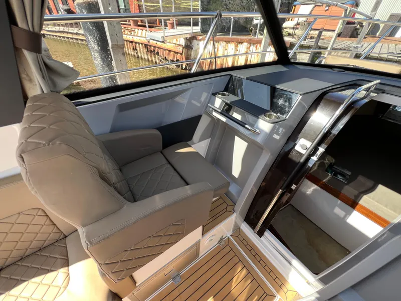Slide: The Image of 2024 Aquador 250 HT boat interior with helm, luxurious seating, and modern dashboard. - 24