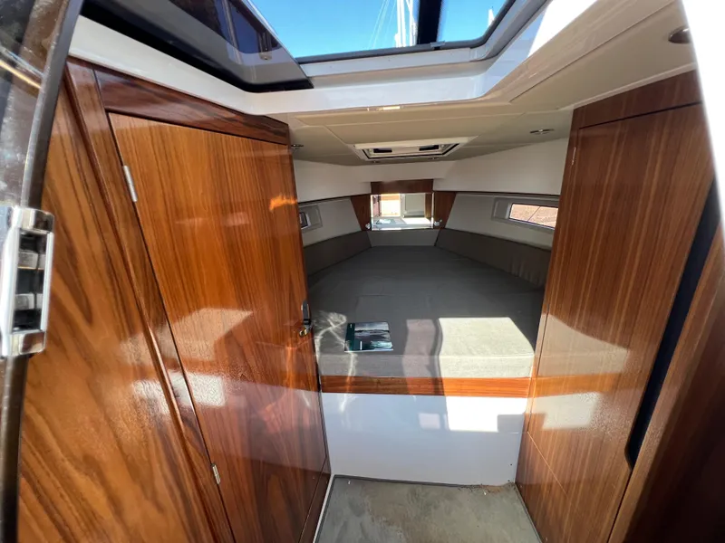 Slide: The Image of 2024 Aquador 250 HT cabin interior with wood finish and skylight. - 25