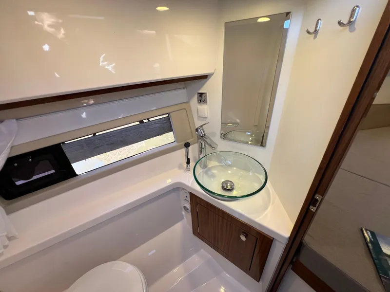 Slide: The Image of 2024 Aquador 250 HT boat bathroom with modern glass sink and sleek design. - 27