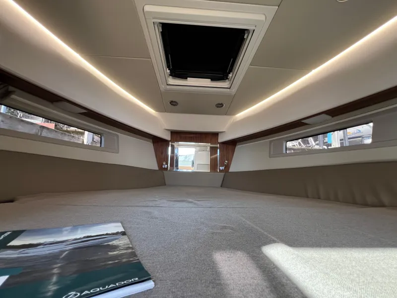 Slide: The Image of 2024 Aquador 250 HT cabin interior with modern design and skylight. - 29