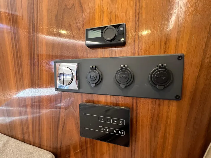Slide: The Image of Control panel on 2024 Aquador 250 HT boat with wood finish and multiple outlets. - 31