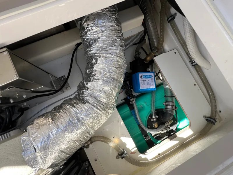 Slide: The Image of Engine compartment of 2024 Aquador 250 HT boat with ductwork and mechanical components. - 34