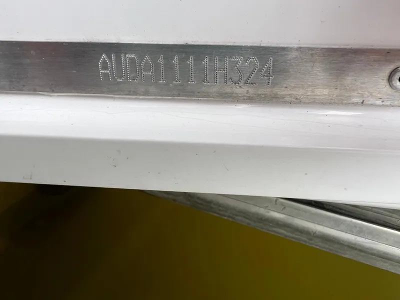 Slide: The Image of 2024 Aquador 250 HT boat hull identification number engraved on metal plate. - 36