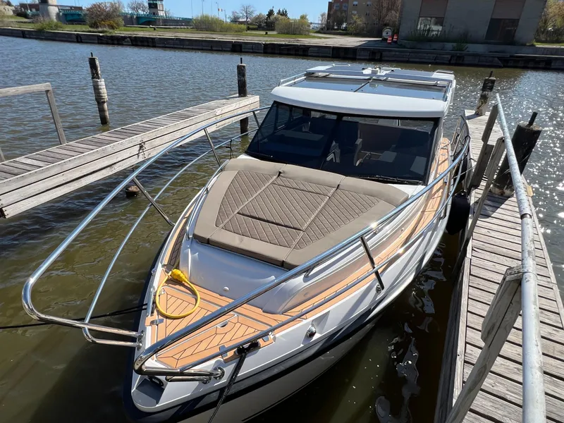 Slide: The Image of 2024 Aquador 250 HT boat docked at a marina, featuring sleek design and spacious deck. - 4
