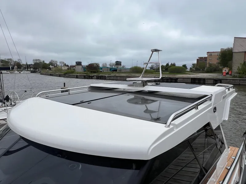 Slide: The Image of 2024 Aquador 250 HT boat docked by a riverside, showcasing sleek design and modern features. - 5
