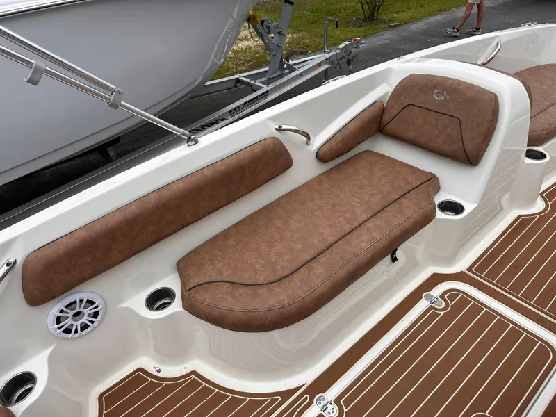 Slide: The Image of 2020 Stingray 182 SC boat interior with brown cushioned seating and wood-patterned flooring. - 11