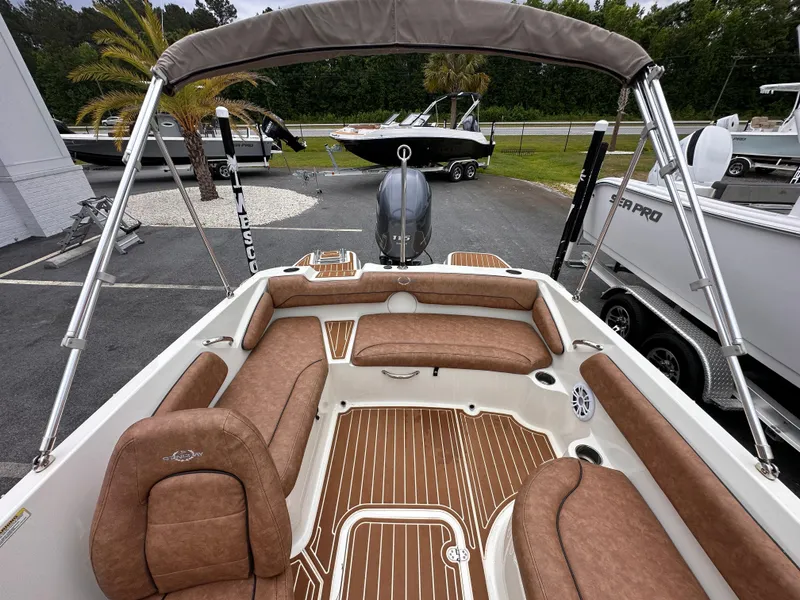 Slide: The Image of 2020 Stingray 182 SC boat interior with brown seating and wood-patterned flooring. - 12