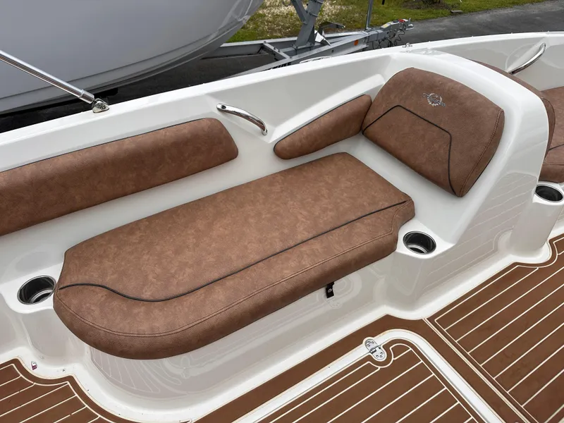 Slide: The Image of 2020 Stingray 182 SC boat interior with brown cushioned seating and cup holders. - 16