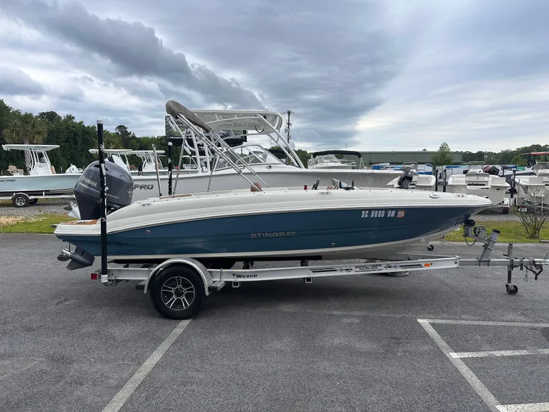 Slide: The Image of 2020 Stingray 182 SC boat on trailer in parking lot, cloudy sky background. - 2