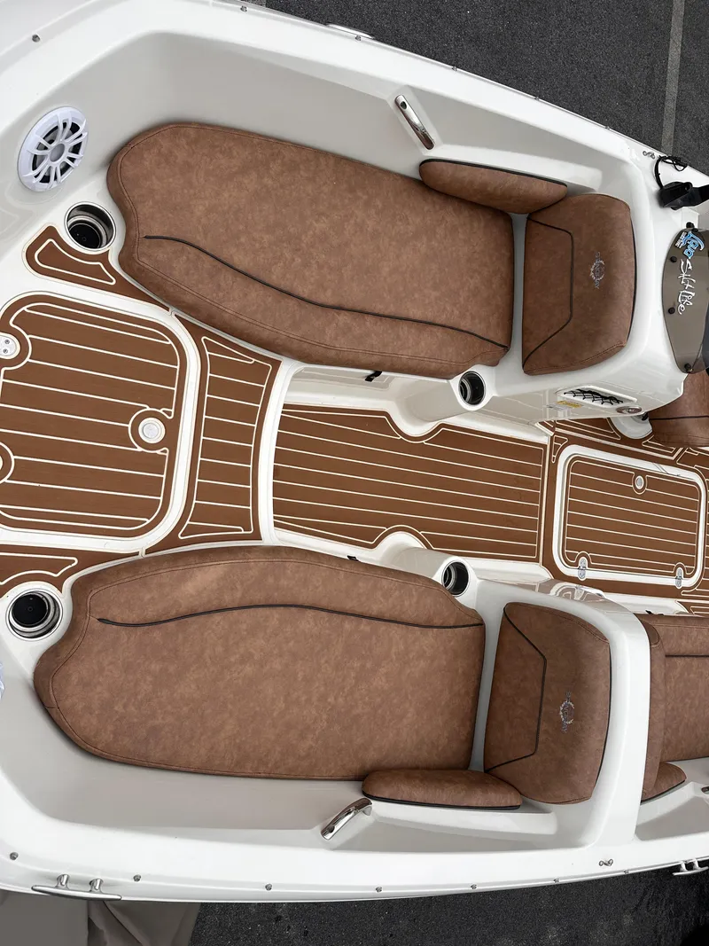Slide: The Image of 2020 Stingray 182 SC boat interior with brown cushioned seating and wood-patterned flooring. - 6