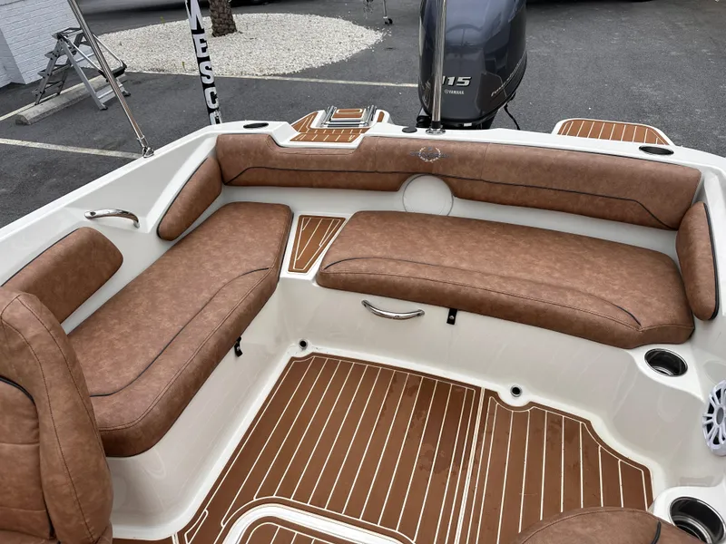 Slide: The Image of 2020 Stingray 182 SC boat interior with brown cushioned seating and wood-patterned flooring. - 7