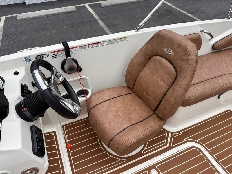 Slide: The Image of 2020 Stingray 182 SC boat interior with brown seating and steering wheel. - 8