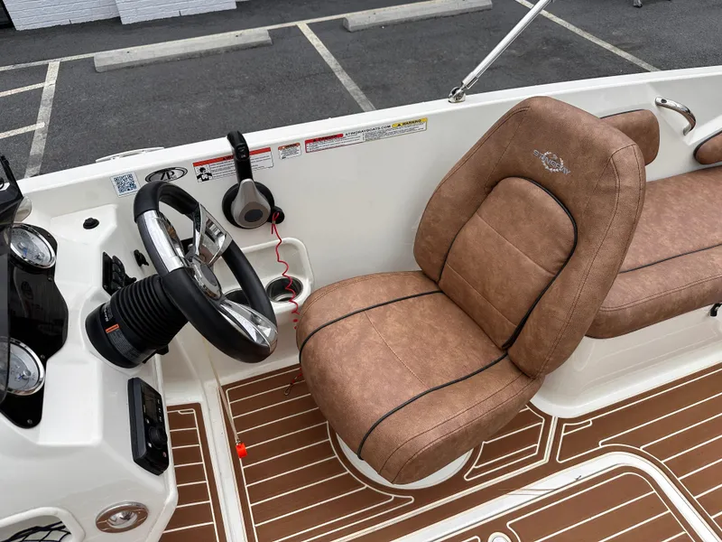 Slide: The Image of 2020 Stingray 182 SC boat interior with brown captain's seat and steering wheel. - 9