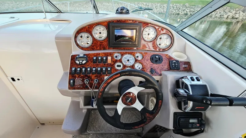 Slide: The Image of 2005 Rinker 300 Express Cruiser dashboard with steering wheel and control panel. - 13