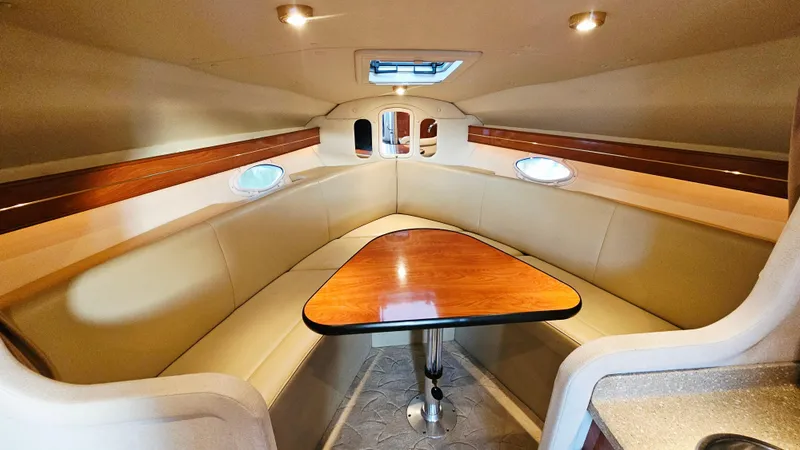 Slide: The Image of 2005 Rinker 300 Express Cruiser interior with cozy seating and wooden table. - 18