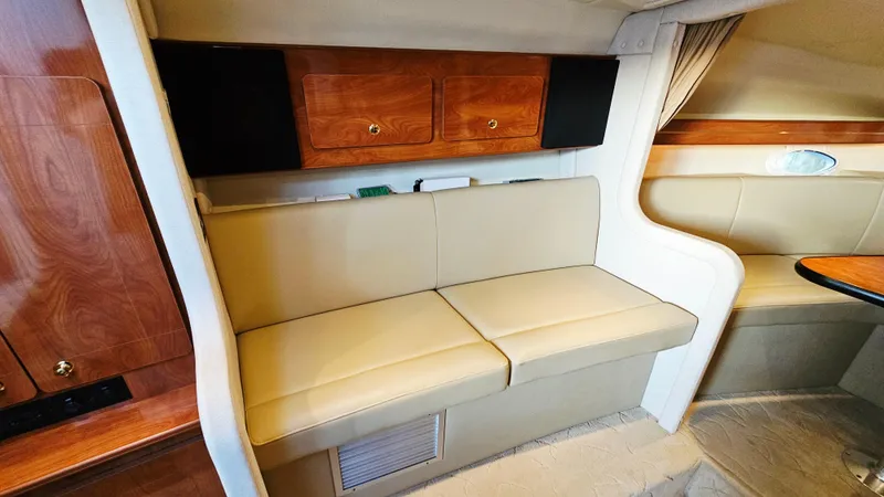 Slide: The Image of 2005 Rinker 300 Express Cruiser interior with beige seating and wooden cabinets. - 19