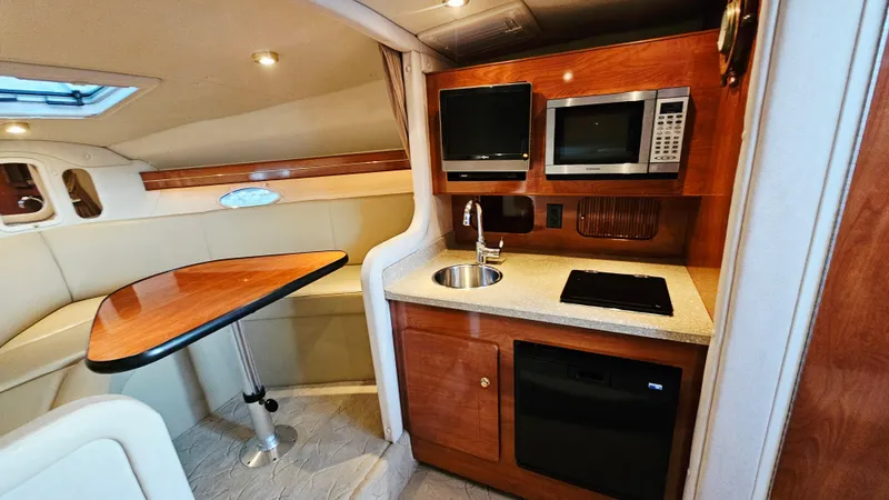 Slide: The Image of 2005 Rinker 300 Express Cruiser interior with kitchenette and dining area. - 20