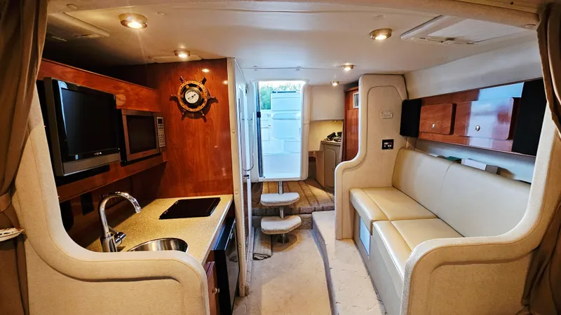 Slide: The Image of Interior of 2005 Rinker 300 Express Cruiser with kitchenette and seating area. - 21