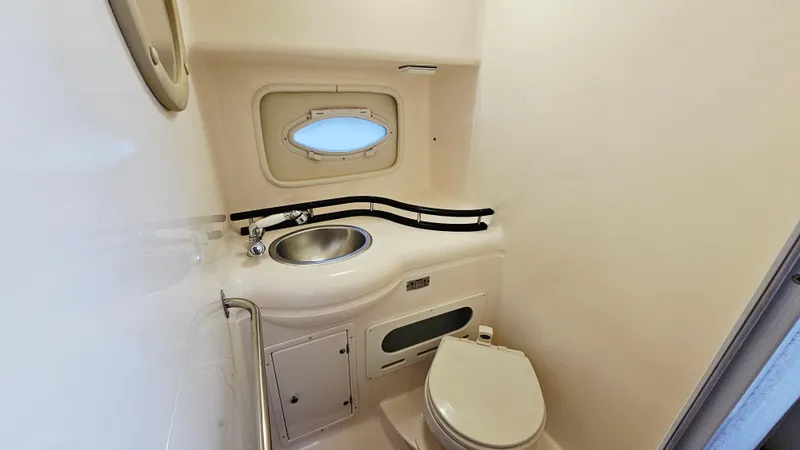 Slide: The Image of 2005 Rinker 300 Express Cruiser bathroom with sink, toilet, and porthole window. - 24