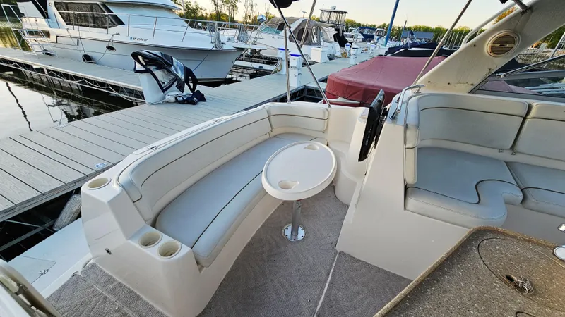 Slide: The Image of 2005 Rinker 300 Express Cruiser interior with seating and table at marina. - 6