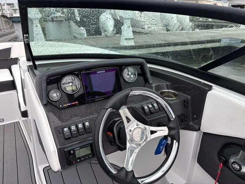 Slide: The Image of 2022 Monterey M-225 boat dashboard with steering wheel, gauges, and navigation system. - 13