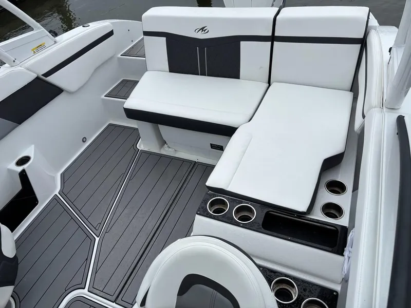 Slide: The Image of 2022 Monterey M-225 boat interior with white seating and cup holders. - 15