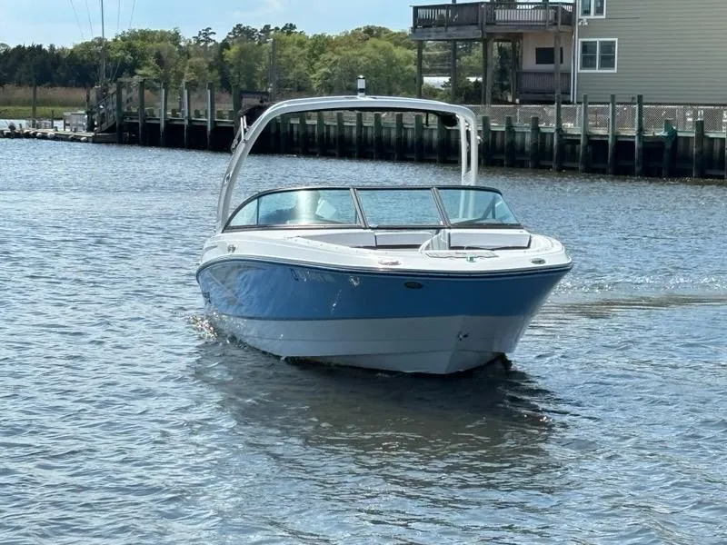 Slide: The Image of 2022 Monterey M-225 boat cruising on a calm waterway near docks and buildings. - 4