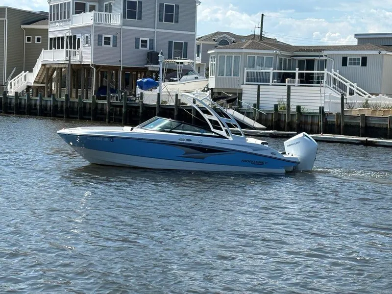 Slide: The Image of 2022 Monterey M-225 boat cruising near waterfront homes. - 5