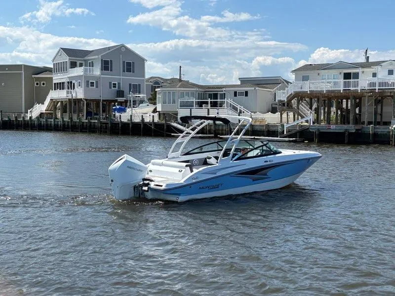 Slide: The Image of 2022 Monterey M-225 boat cruising near waterfront homes under a clear sky. - 7