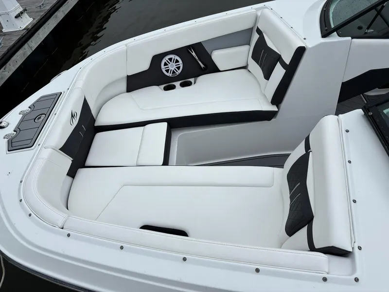 Slide: The Image of 2022 Monterey M-225 boat interior with white and black seating, cup holders, and speaker. - 9