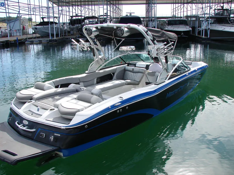 Slide: The Image of 2014 MasterCraft X46 boat docked in marina, featuring sleek design and spacious seating. - 2