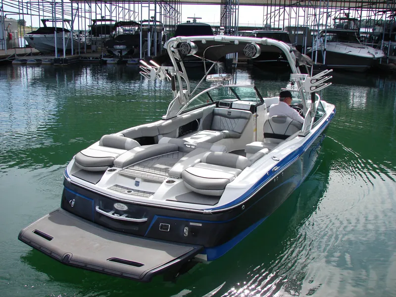 Slide: The Image of 2014 MasterCraft X46 boat docked in marina, featuring sleek design and spacious seating. - 3