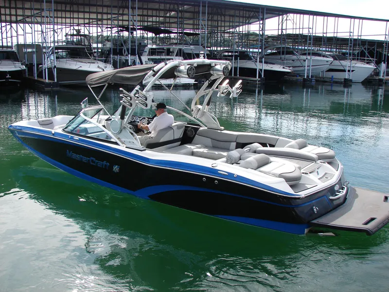Slide: The Image of 2014 MasterCraft X46 boat docked in marina, featuring sleek design and spacious seating. - 4