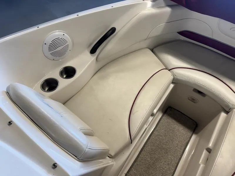 Slide: The Image of Interior of a 2006 Monterey 234FS boat with white seating and cup holders. - 10