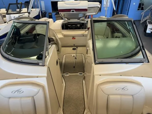 Slide: The Image of 2006 Monterey 234FS boat interior with open seating and windshield, displayed in showroom. - 13