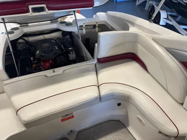 Slide: The Image of 2006 Monterey 234FS boat interior with engine compartment open, featuring white and red seating. - 17