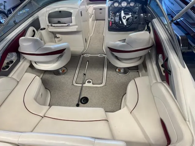 Slide: The Image of Interior of a 2006 Monterey 234FS boat with white seating and dashboard. - 22