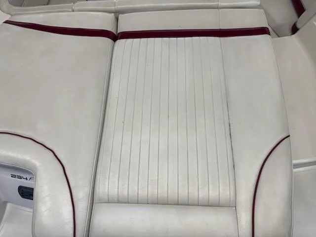 Slide: The Image of White leather seating on a 2006 Monterey 234FS boat with red accents. - 25