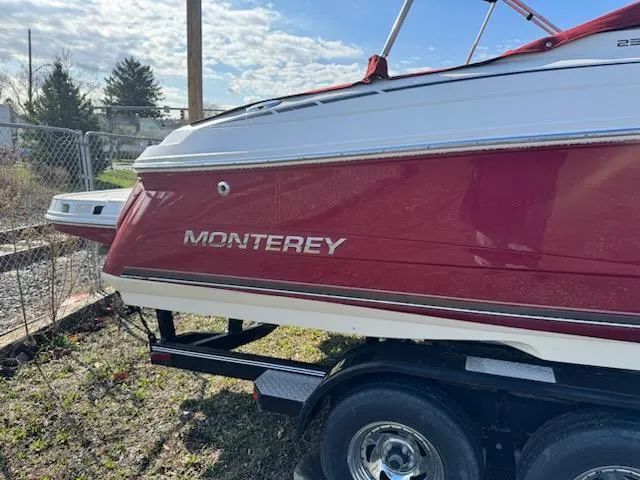 Slide: The Image of 2006 Monterey 234FS boat on trailer, red and white exterior, parked outdoors. - 3