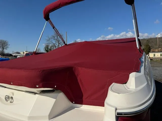 Slide: The Image of 2006 Monterey 234FS boat with red cover and bimini top, rear view. - 6